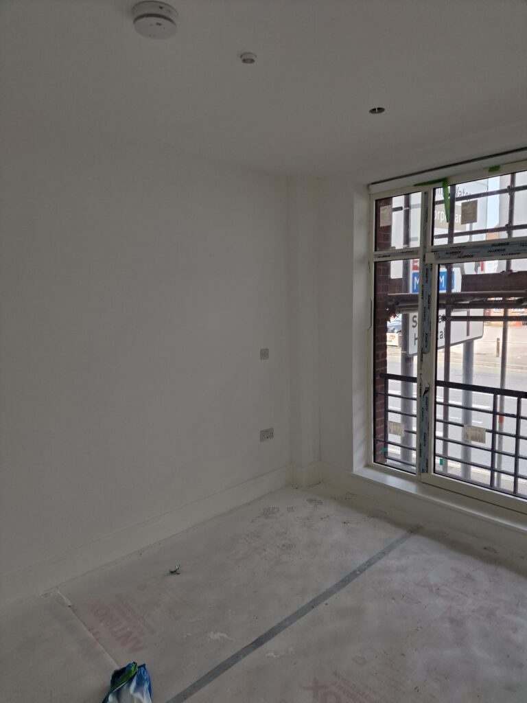 An image showing an empty refurbished room corner which has been cleaned.